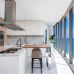 A panoramic shot of an open-concept kitchen with large glass doors.